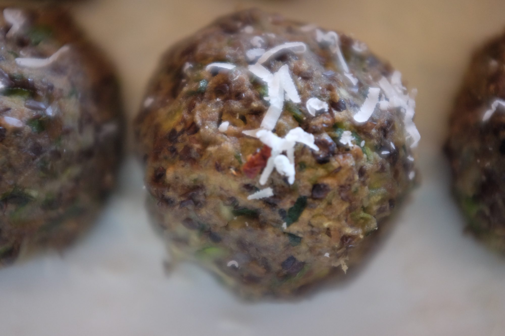 A close up view of vegetarian beluga lentil meatballs made with black lentils, zucchinis, sweet potato and herbs by Foodjoya