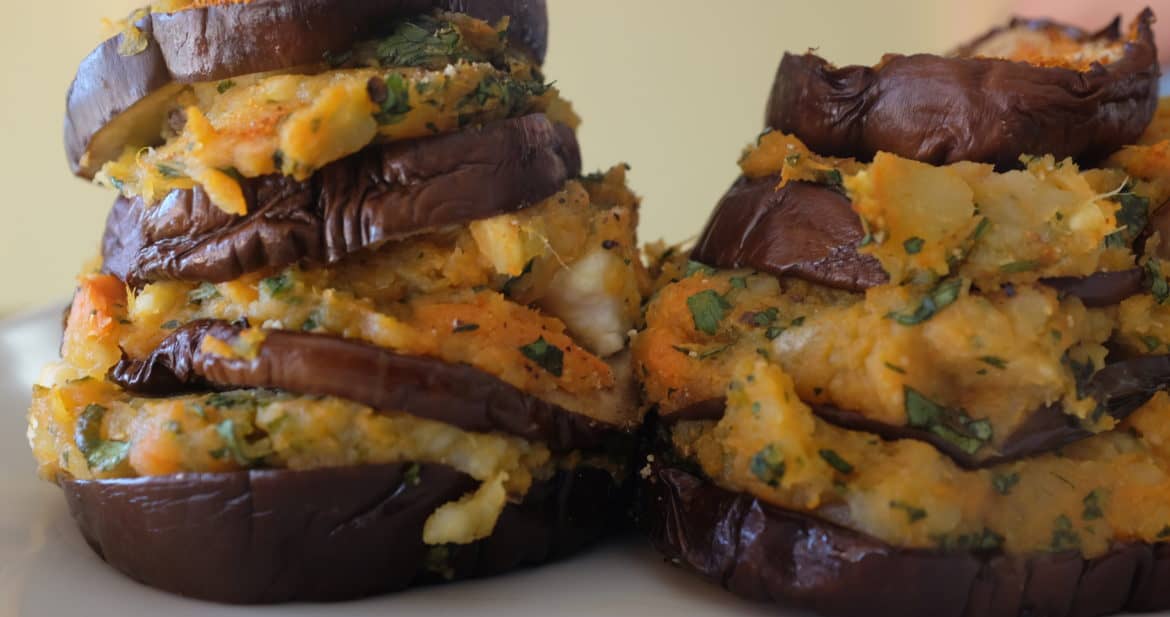 A close up view of roasted eggplant stacks with sweet potatoes, herbs and feta, displaying the layers, by Foodjoya