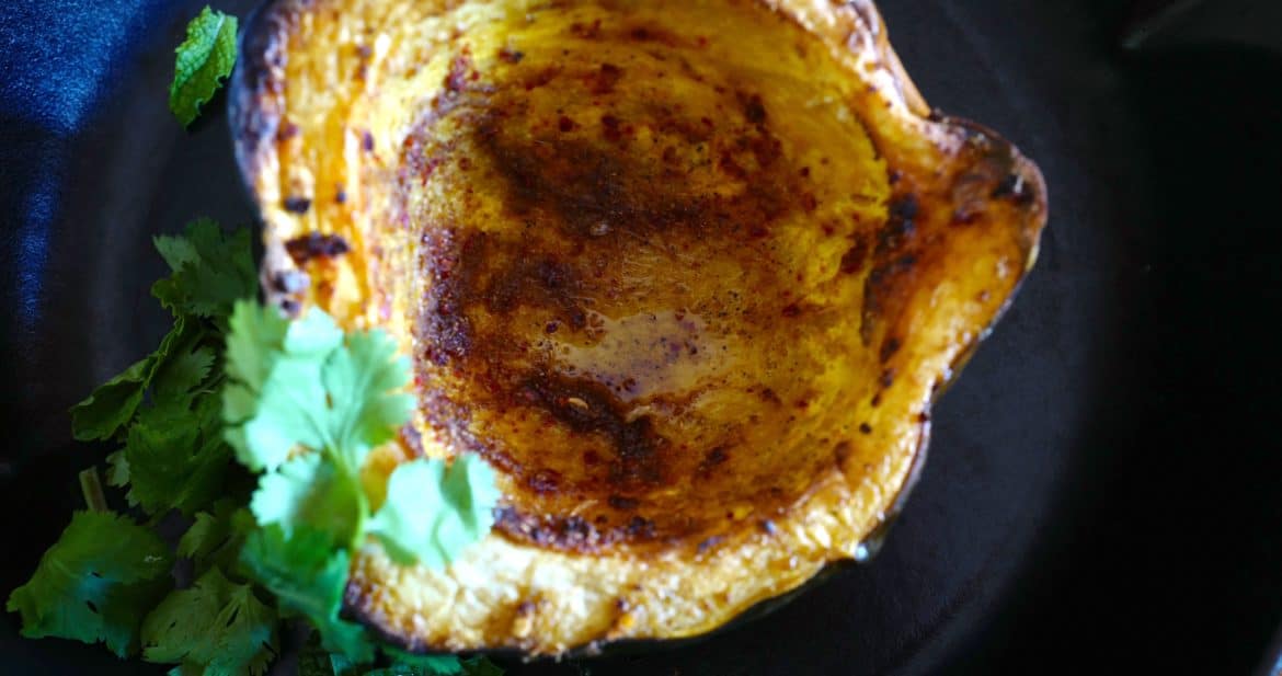 Roasted acorn squash (winter squash) with spices, avocado oil, served next to cilantro and mint by Foodjoya.