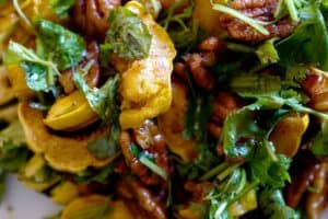 Delicata squash salad with herbs and spicy pecans close up by foodjoya