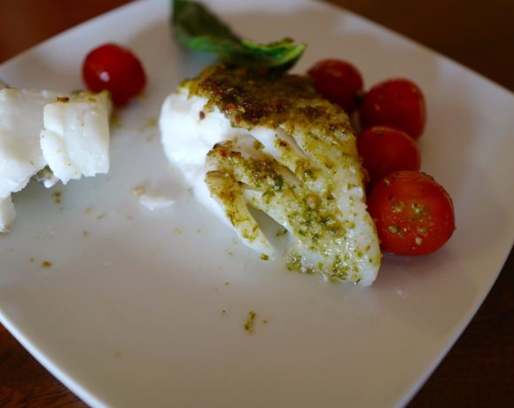 Pesto baked cod cut with a fork by foodjoya
